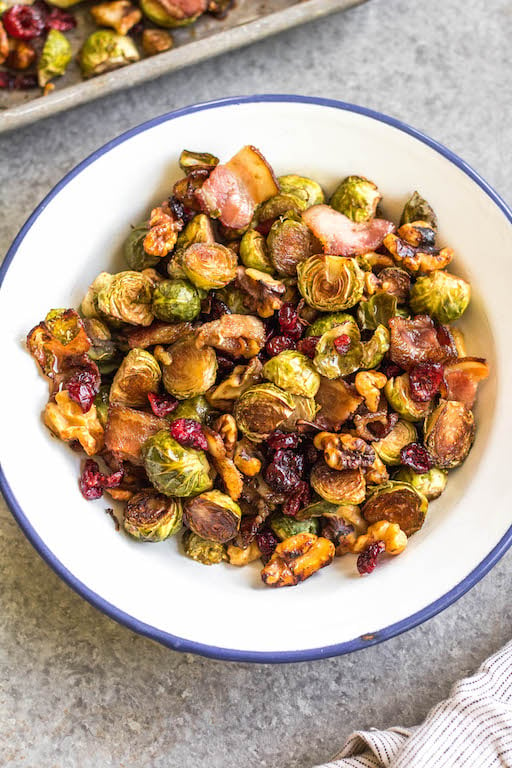 These roasted balsamic Brussels sprouts are absolutely delicious. Baked with dried cranberries, bacon and walnuts, they are a healthy, Whole30 side dish everyone will love. They're also paleo, gluten-free and low carb, and a really easy and tasty way to get vegetables on the table. With only 5 ingredients and 30 minutes, this is sure to be your go-to method for cooking brussels sprouts! #whole30vegetables #brusselssproutsrecipes #roastedbrusselssprouts #paleovegetables #baconrecipes #easyvegetablerecipes