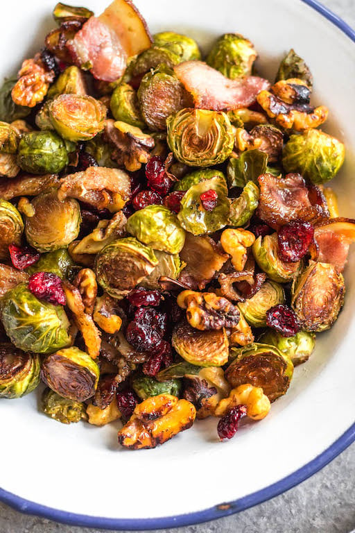 These roasted balsamic Brussels sprouts are absolutely delicious. Baked with dried cranberries, bacon and walnuts, they are a healthy, Whole30 side dish everyone will love. They're also paleo, gluten-free and low carb, and a really easy and tasty way to get vegetables on the table. With only 5 ingredients and 30 minutes, this is sure to be your go-to method for cooking brussels sprouts! #whole30vegetables #brusselssproutsrecipes #roastedbrusselssprouts #paleovegetables #baconrecipes #easyvegetablerecipes