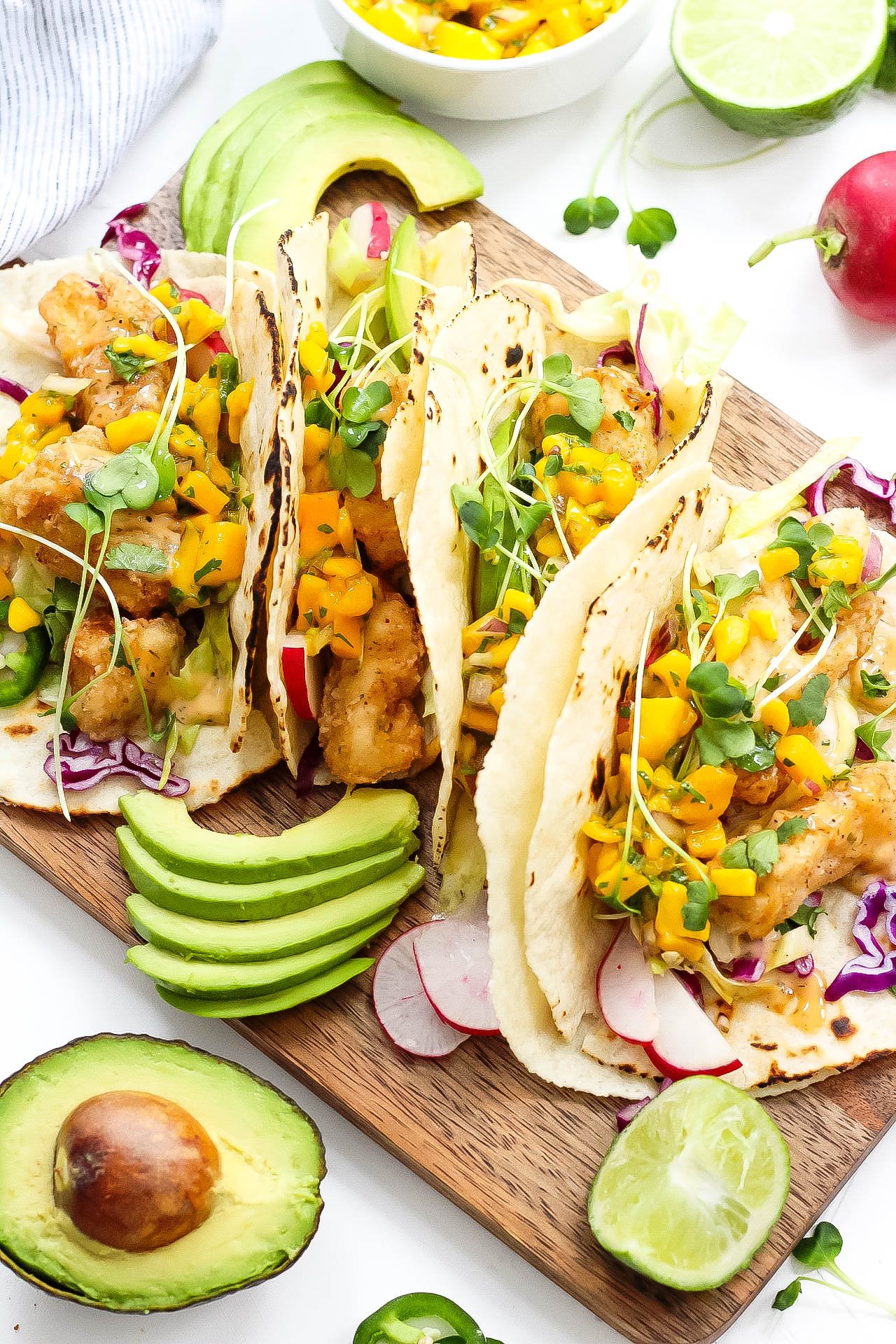 These grain free tacos is a fun and quick breaded fish recipe with easy mango salsa! Paleo fish tacos are totally gluten-free, family friendly, and even Whole30 if you skip the grain free tortilla and go for a lettuce wrap fish taco! Either way, these paleo fish tacos will be a summer favorite! #paleofishtacos #grainfreetacos #paleofish