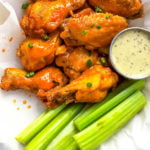 Healthy, low carb buffalo wings in the air fryer! This paleo air fryer chicken wing recipe is Whole30 and doesn't leave you any dishes to wash! It's a paleo family friendly option that you can make in the oven too! #whole30airfryer #airfryerwings #airfryerpaleo #airfryerketo
