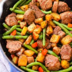 This easy Whole30 steak skillet is full of flavor and healthy veggies. It's a new favorite Paleo one pan meal around here that only takes 20 minutes! Making everything in one skillet is my go-to for quick meal prepping or making a clean eating and family friendly weeknight dinner. #whole30beefrecipes #whole30onepan #paleoonepan #paleobeefrecipes