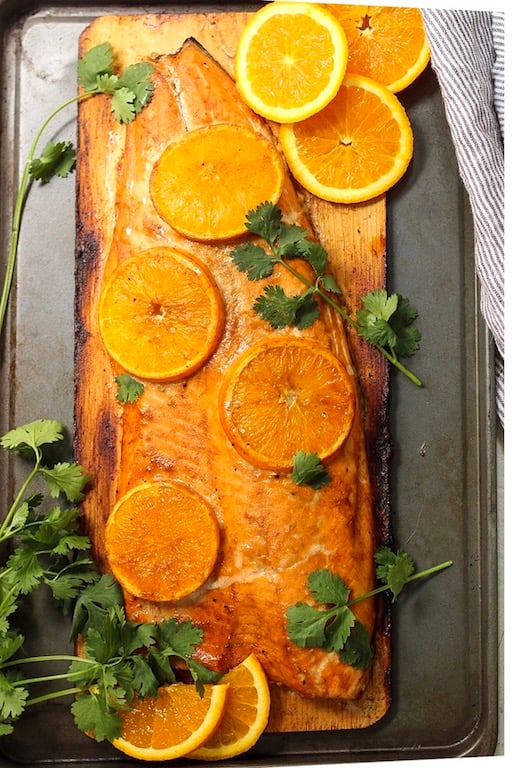 This Whole30 and Paleo orange glazed cedar plank salmon is every bit as delicious and easy as it looks! It's one of my favorite simple ways to cook salmon. The Paleo orange glaze takes a minute to put together and the cedar ramps up the taste of the salmon even more! #whole30salmon #whole30grilling #cedarplanksalmon