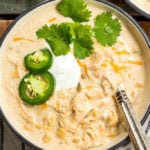 This slow cooker white chicken chili is a family recipe I grew up with, and it's every bit as hearty and delicious as it is easy to make. It's made with a few simple ingredients like white corn, shredded chicken, cream cheese, northern beans and the perfect spice combination. With only a couple of minutes of prep work, this hands off dinner is a great recipe for a chilly fall or winter night. #slowcookerchili #whitechickenchili #slowcookerwhitechickenchili