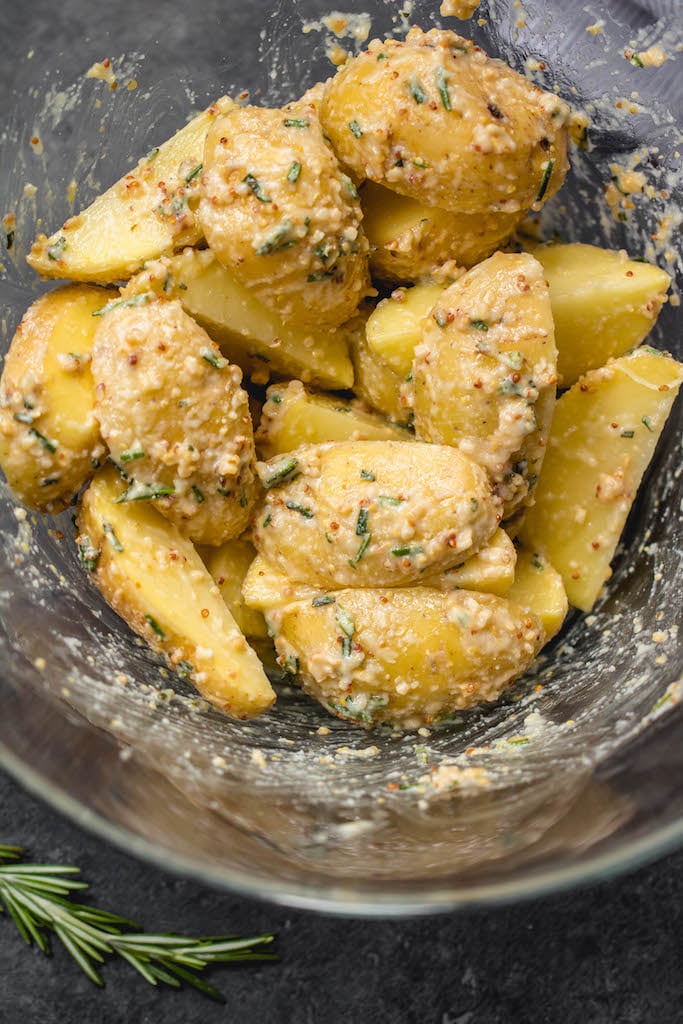 These garlicky, herb and mustard roasted potatoes are baked to crispy perfection. This Whole30 and paleo side dish takes just minutes to throw together for an easy weeknight dinner and are delicious enough to be a crowd pleaser at any holiday meal. The potato side dish requires only a handful of simple ingredients, 30 minutes in the oven and reheats great for leftovers or breakfast #whole30sidedish #whole30potatoes #paleosidedish #mustardpotatoes