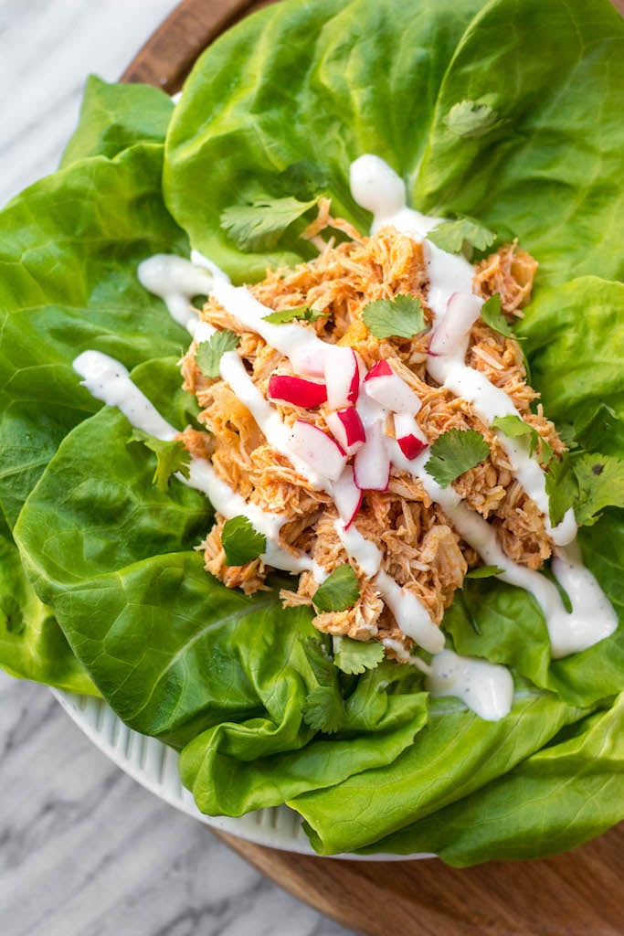 This slow cooker buffalo chicken could not get any easier. It's a Paleo, Whole30 and Keto meal that you can just dump into the slow cooker and come back later to find dinner ready. It's also a great meal prep recipe that can be used for buffalo chicken salads, wraps, tacos and much more. #whole30 #whole30buffalochicken #buffalochicken #slowcookerbuffalochicken #ketoslowcooker #paleo
