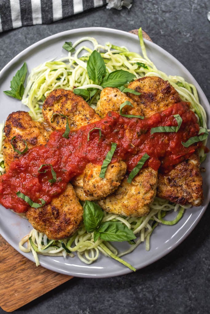 This cheeseless Whole30 chicken parm is an easy weeknight meal that's both healthy and delicious. It's paleo, dairy-free and gluten-free, and is sure to be a family favorite! If you're bored with baked chicken, this simple Whole30 chicken recipe is a great way to change up your week or your meal prep. #whole30chicken #whole30chickenparm #dairyfree #paleochicken #glutenfree #whole30chickenrecipes #glutenfreechicken