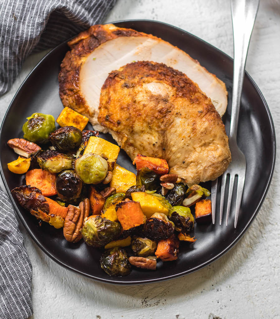 This easy, stress-free oven roasted whole turkey recipe with maple glazed winter vegetables is the perfect addition to any holiday event or family meal. With the maple pecan veggie side dish cooked right at the same time, you can be sure dinner is both simple to make and healthy! #wholeturkey #ovenroastedturkey #thanksgivingrecipes #thanksgivingturkeyrecipes