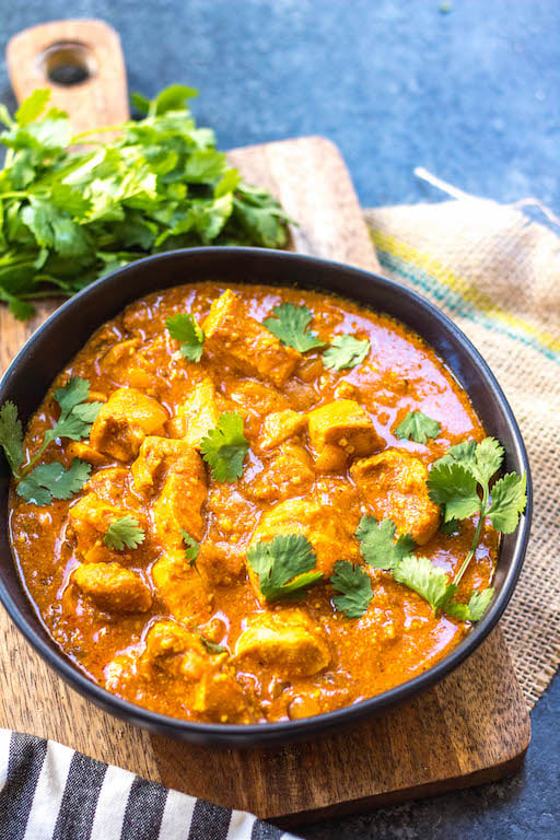 This paleo and Whole30 slow cooker chicken tikka masala recipe is every bit as easy as it is delicious. It's a truly set it and forget it recipe that only requires a few simple ingredients, chicken and a crock pot. The end result is a tasty, healthy and family friendly weeknight dinner or meal for meal prep for the week! It's gluten-free, dairy-free and keto, so it's great for any type of eater in your family! #whole30slowcooker #whole30chickentikkamasala #lowcarbslowcooker #ketoslowcooker #paleochickentikkamasala