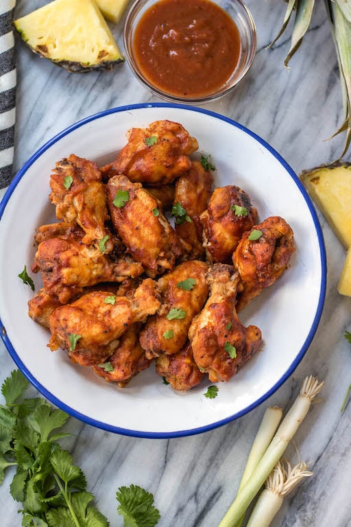 These slow cooker BBQ chicken wings are perfect for meal prep, or for a healthy appetizer or snack. They've got a Hawaiian spin to add some exciting flavor to the BBQ, only a few simple ingredients in a crockpot, and are Whole30, paleo and gluten-free. This is a great hands-off method to cook an easy chicken recipe everyone will love. #whole30slowcooker #whole30chickenwings #crockpotchicken #healthychickenwings #paleochickenrecipes
