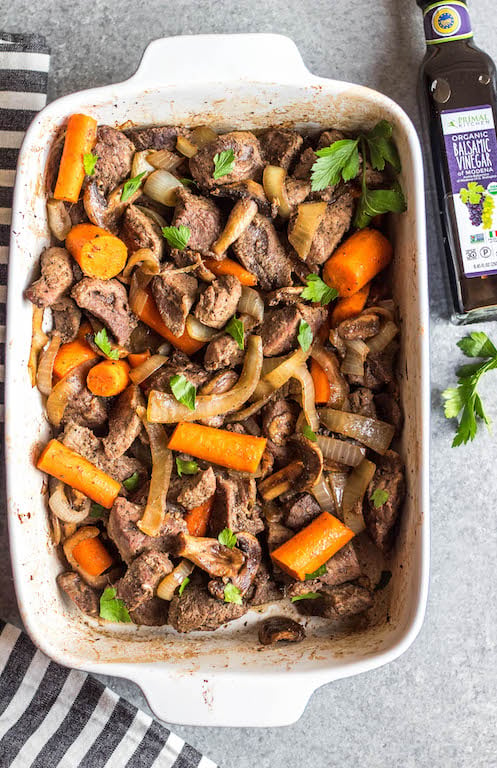 This easy oven roasted beef and vegetables recipe is a simple yet healthy dinner recipe with only a few ingredients and little hands on time. It's a family friendly meal ideal that's also Whole30, Paleo, gluten-free and dairy-free. The beef chunks using a chuck roast cook perfectly in one pan with carrots, while the mushrooms and onions are caramelized and mixed in to make this recipe hearty, cozy and delicious! #whole30recipes #whole30beefrecipes #whole30dinner #paleodinner #easywhole30recipes