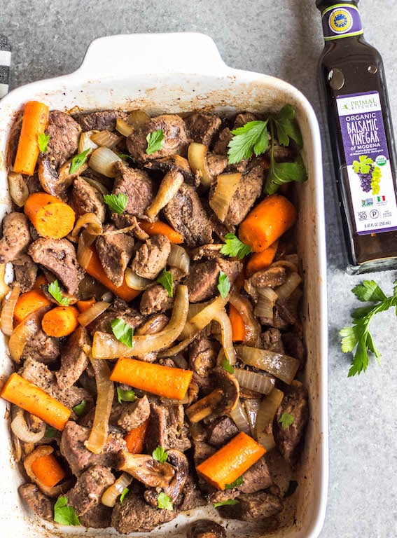 This easy oven roasted beef and vegetables recipe is a simple yet healthy dinner recipe with only a few ingredients and little hands on time. It's a family friendly meal ideal that's also Whole30, Paleo, gluten-free and dairy-free. The beef chunks using a chuck roast cook perfectly in one pan with carrots, while the mushrooms and onions are caramelized and mixed in to make this recipe hearty, cozy and delicious! #whole30recipes #whole30beefrecipes #whole30dinner #paleodinner #easywhole30recipes