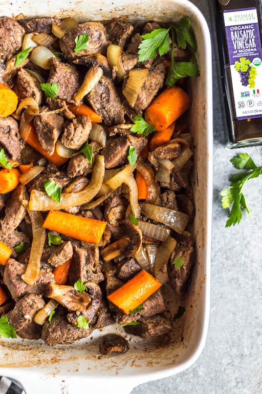 This easy oven roasted beef and vegetables recipe is a simple yet healthy dinner recipe with only a few ingredients and little hands on time. It's a family friendly meal ideal that's also Whole30, Paleo, gluten-free and dairy-free. The beef chunks using a chuck roast cook perfectly in one pan with carrots, while the mushrooms and onions are caramelized and mixed in to make this recipe hearty, cozy and delicious! #whole30recipes #whole30beefrecipes #whole30dinner #paleodinner #easywhole30recipes