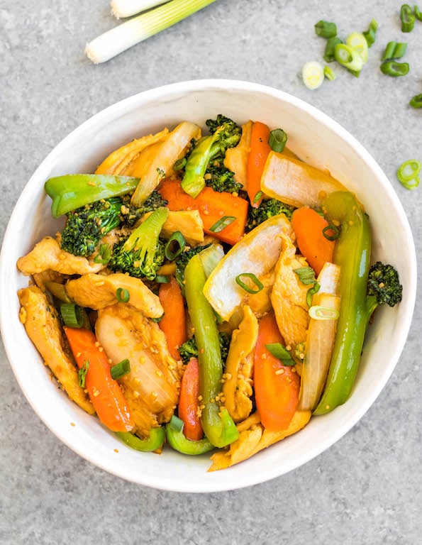 This easy garlic chicken stir fry gets dinner ready to eat in 30 minutes. It's incredibly simple to make for a weeknight meal, full of vegetables like broccoli, carrots and onion, and makes great leftovers for lunch meal prep. This is a family friendly Whole30, paleo, low carb and gluten-free recipe that everyone will love! The sauce is made from only a few pantry staple ingredients, making this a budget friendly one pot recipe, too. #whole30stirfry #garlicchicken #ketochicken #whole30chicken #whole30dinner #lowcarbchicken