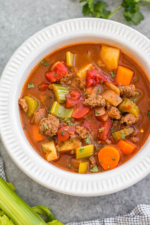 This Whole30 ground beef and vegetable soup is an easy family friendly and budget friendly recipe that's perfect for a quick weeknight meal or for meal prep. It's a cozy soup that's full of filling vegetables like carrots, potatoes and celery, with tons of flavor from a few common spices! It's also paleo, gluten-free and dairy-free, while still being something everyone will love. #whole30soup #whole30beefrecipes #groundbeef #healthysoup #paleo