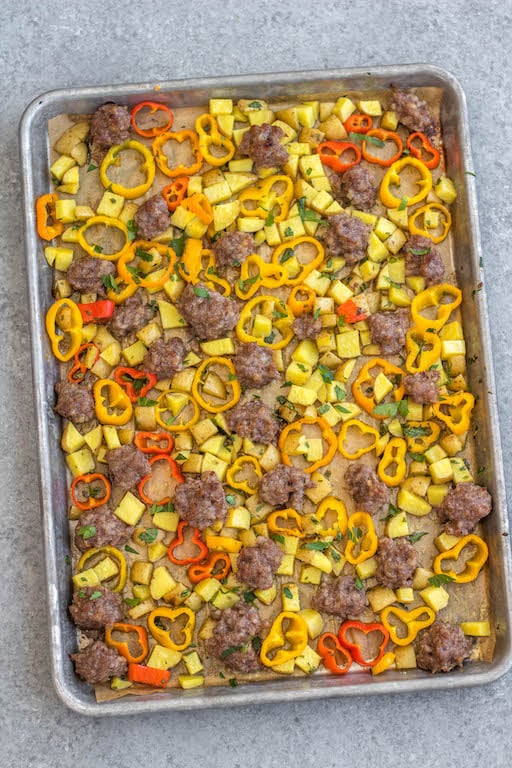 This easy sheet pan sausage breakfast recipe is a healthy meal prep recipe that's only 5 ingredients! The breakfast sausage is paired with seasoned potatoes and peppers all on one pan, put into the oven and ready to go with very little hands-on time. It's also great for a weeknight dinner for a simple vegetable and protein meal. This is a quick Whole30, paleo, gluten-free and egg-free breakfast recipe the whole family will enjoy! #whole30breakfast #whole30sheetpan #sheetpanbreakfast #glutenfree #eggfree #paleobreakfast