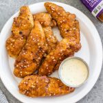 These oven baked teriyaki chicken tenders are easy to make, full of flavor and a family friendly dinner recipe everyone will enjoy. They're breaded in a paleo, Whole30 and gluten-free coating, baked and tossed in a sticky, delicious soy-free teriyaki sauce. These tenders are great on their own dipped into your favorite sauce, or over a big salad, and perfect for a quick weeknight meal. #whole30chicken #whole30teriyakichicken #teriyakichickentenders #paleochicken #glutenfreechicken #whole30chickentenders