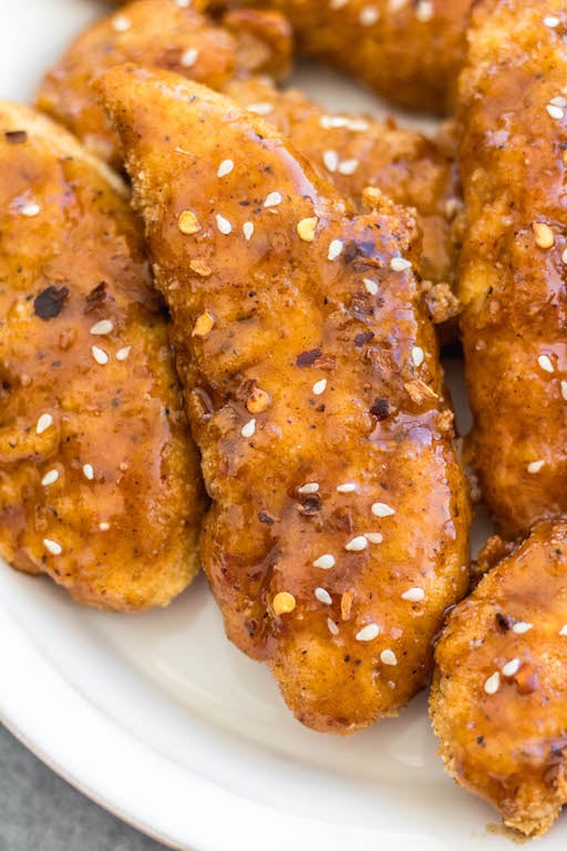 These oven baked teriyaki chicken tenders are easy to make, full of flavor and a family friendly dinner recipe everyone will enjoy. They're breaded in a paleo, Whole30 and gluten-free coating, baked and tossed in a sticky, delicious soy-free teriyaki sauce. These tenders are great on their own dipped into your favorite sauce, or over a big salad, and perfect for a quick weeknight meal. #whole30chicken #whole30teriyakichicken #teriyakichickentenders #paleochicken #glutenfreechicken #whole30chickentenders