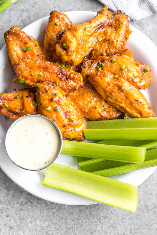 These Whole30 smoked buffalo wings are simple, easy to prepare, and always a crowd pleaser! These chicken wings require a few ingredients, and are not only Whole30, but also Paleo, gluten-free and low carb/keto. These wings are perfect for a healthy weeknight dinner, meal prep, or any gathering. Smoking wings is a straightforward process that anyone can master! #whole30chickenwings #whole30chicken #smoker #smokedwings #buffalowings #ketochicken