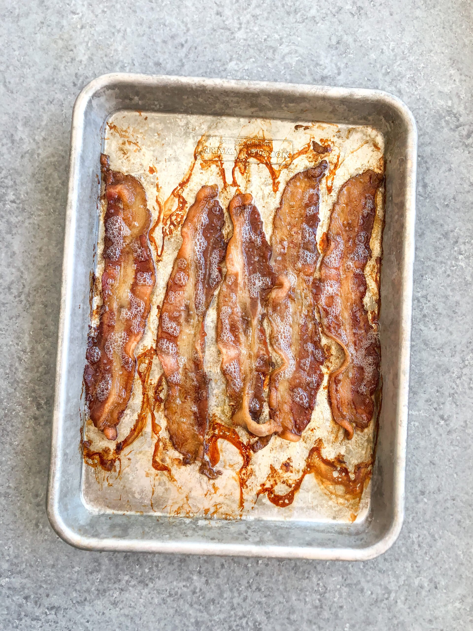 Baking your bacon in the oven is the easy, mess free and best way to do it! Once you try oven cooked bacon you won't go back to pan frying. With this method you can also control how crispy your bacon is too, so it comes out to your perfect bacon texture preference every time! #ovencookedbacon #baconrecipes #porkrecipes #whole30bacon