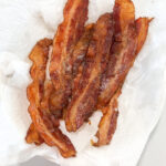 Baking your bacon in the oven is the easy, mess free and best way to do it! Once you try oven cooked bacon you won't go back to pan frying. With this method you can also control how crispy your bacon is too, so it comes out to your perfect bacon texture preference every time! #ovencookedbacon #baconrecipes #porkrecipes #whole30bacon