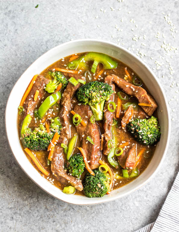 This easy slow cooker Mongolian beef is quick to throw into the crock pot, and is Whole30, Paleo, low carb and gluten-free. It only needs a handful of simple ingredients to make the sauce, along with flank steak, carrots, bell pepper and broccoli for the vegetables. This family friendly meal is perfect for dinner or for a healthy meal prep recipe! #whole30recipes #whole30beef #mongolianbeef #slowcooker #crockpot