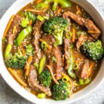 This easy slow cooker Mongolian beef is quick to throw into the crock pot, and is Whole30, Paleo, low carb and gluten-free. It only needs a handful of simple ingredients to make the sauce, along with flank steak, carrots, bell pepper and broccoli for the vegetables. This family friendly meal is perfect for dinner or for a healthy meal prep recipe! #whole30recipes #whole30beef #mongolianbeef #slowcooker #crockpot