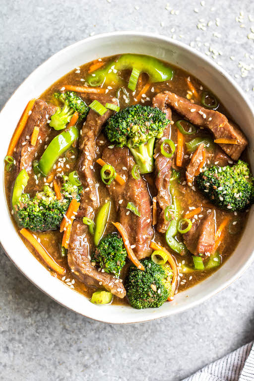 This easy slow cooker Mongolian beef is quick to throw into the crock pot, and is Whole30, Paleo, low carb and gluten-free. It only needs a handful of simple ingredients to make the sauce, along with flank steak, carrots, bell pepper and broccoli for the vegetables. This family friendly meal is perfect for dinner or for a healthy meal prep recipe! #whole30recipes #whole30beef #mongolianbeef #slowcooker #crockpot