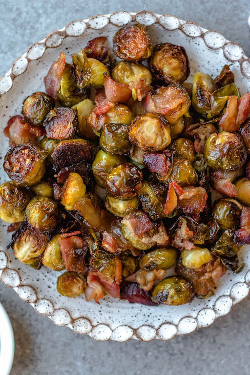 These maple bacon Brussels sprouts are an easy, healthy side dish that works for both the holidays or just a delicious way to prep a vegetable side for a weeknight dinner! There are only 4 simple ingredients and one dish needed, which makes them a quick paleo, gluten-free and dairy-free vegetable recipe option that the whole family will love. The crispy bacon and maple flavors will have everyone eating their Brussels sprouts! #vegetablesides #holidayrecipes #paleovegetables #brusselssprouts #baconrecipes