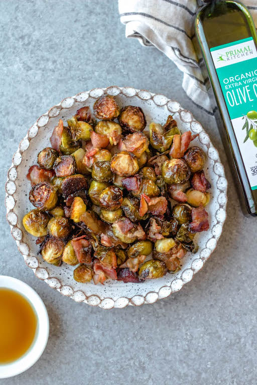 These maple bacon Brussels sprouts are an easy, healthy side dish that works for both the holidays or just a delicious way to prep a vegetable side for a weeknight dinner! There are only 4 simple ingredients and one dish needed, which makes them a quick paleo, gluten-free and dairy-free vegetable recipe option that the whole family will love. The crispy bacon and maple flavors will have everyone eating their Brussels sprouts! #vegetablesides #holidayrecipes #paleovegetables #brusselssprouts #baconrecipes