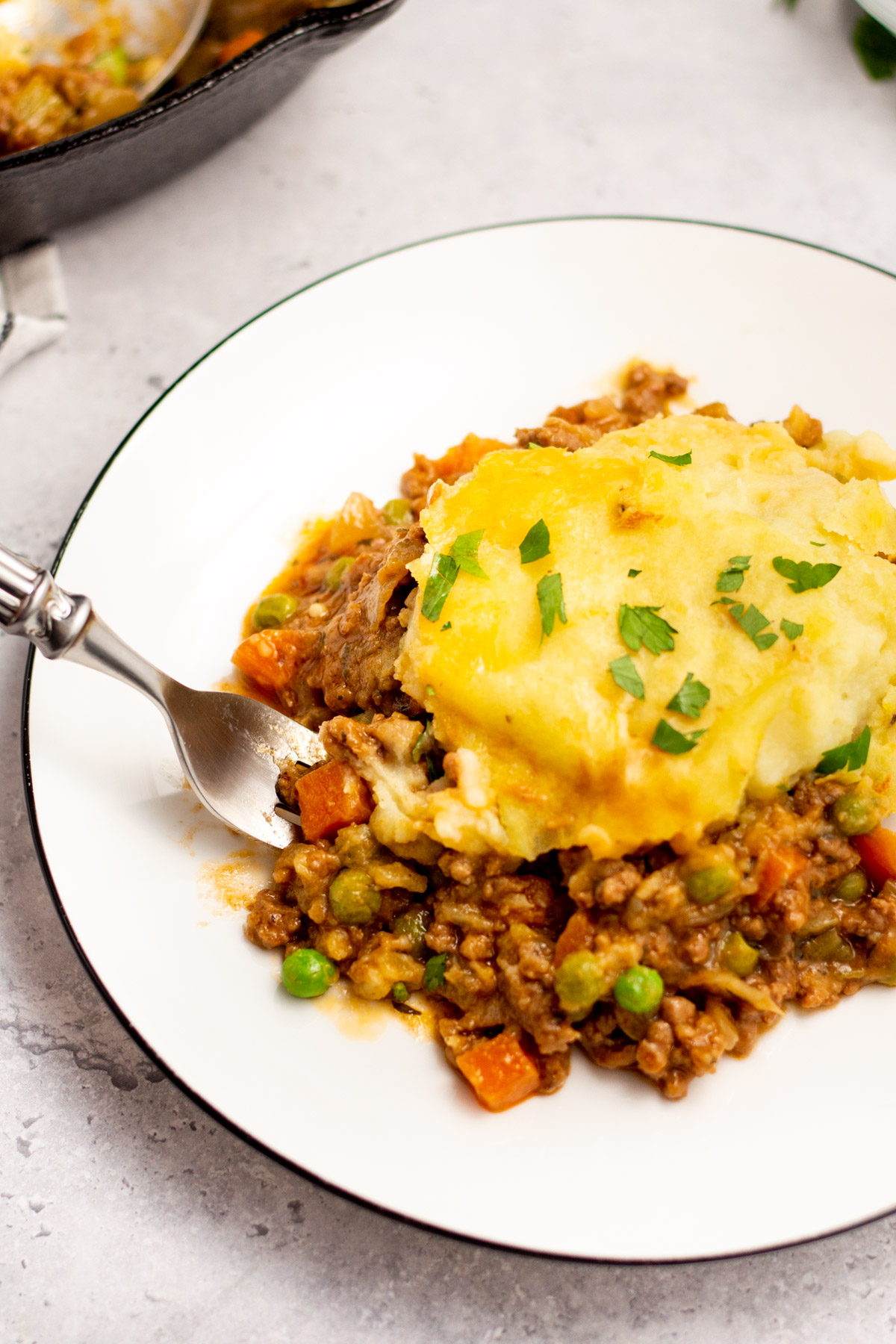 This Whole30 Shepherd's Pie recipe is baked in an oven proof skillet which makes the cooking process simple and easy. It's also a budget-friendly ground beef recipe that's paleo, gluten-free, dairy-free and can be made low carb. With vegetables like carrots, onions, celery and peas mixed in with a flavorful gravy, the filling is a perfect companion for the creamy mashed potatoes. It's a hearty, cozy recipe that's family friendly and also great for meal prep! #groundbeefrecipes #whole30beef #whole30recipes #paleogroundbeef