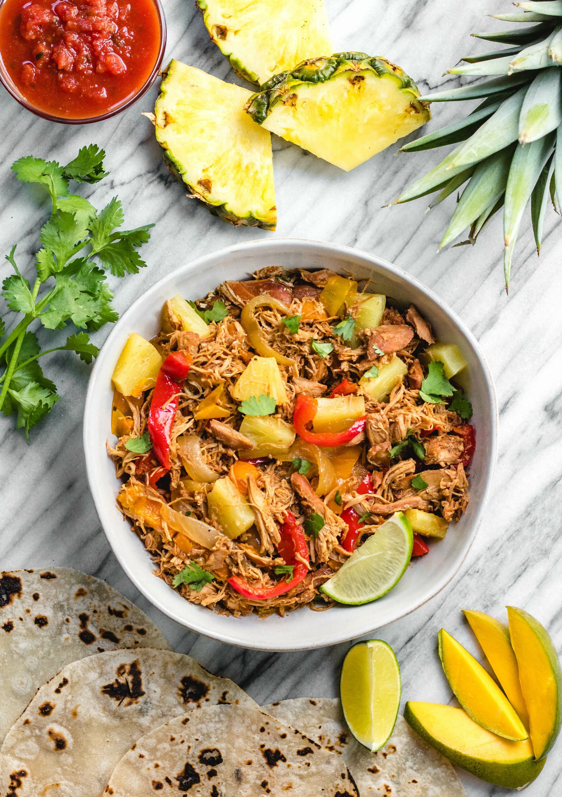 This easy Whole30 slow cooker Hawaiian chicken fajitas recipe is perfect for an easy family-friendly weeknight meal. It's a simple set it and forget crockpot meal that's also paleo, gluten-free and dairy-free. The tender, fall apart chicken thighs and vegetables can be served in wraps, as a salad over greens, or as part of a taco bar! #whole30chicken #whole30slowcooker #whole30fajitas #chickenfajitas