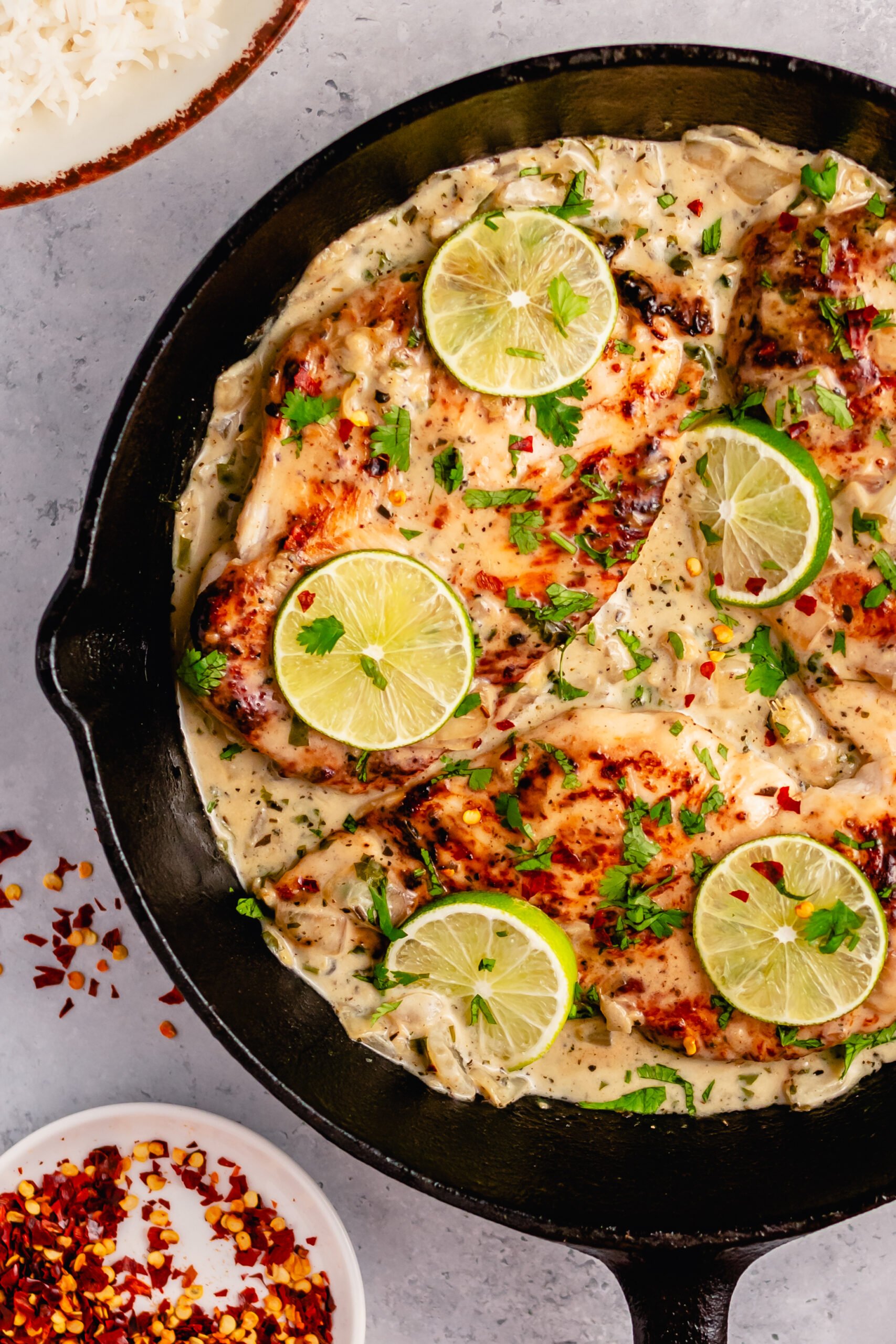 This Whole30 coconut lime chicken skillet is a gluten free, dairy free, and paleo chicken recipe that is made all in one pan! The creamy coconut sauce and chicken breasts are perfectly seasoned with lime, onion, cilantro and garlic. It all comes together in about 30 minutes, and is great for an easy Whole30 dinner that's family friendly, or a healthy meal prep recipe for lunches during the week. #coconutchicken #whole30chicken #whole30skillet #onepanmeal