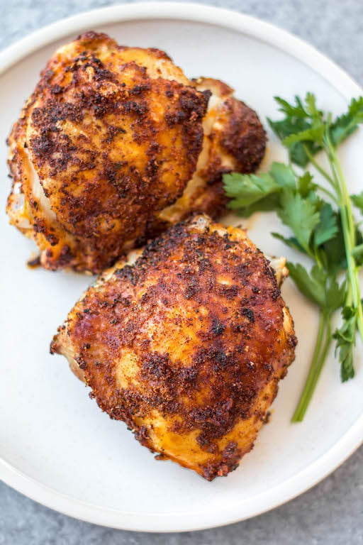 These Whole30 air fryer bone in chicken thighs are so simple and flavorful. The skin gets crispy while the inside stays juicy and tender. They're the perfect option for a quick weeknight dinner and are done in under 30 minutes. Not only are these bone in chicken thighs Whole30, but they're also paleo, gluten free and low carb. #airfryerchicken #whole30airfryer #paleorecipes #glutenfreeairfryer #chickenthighs