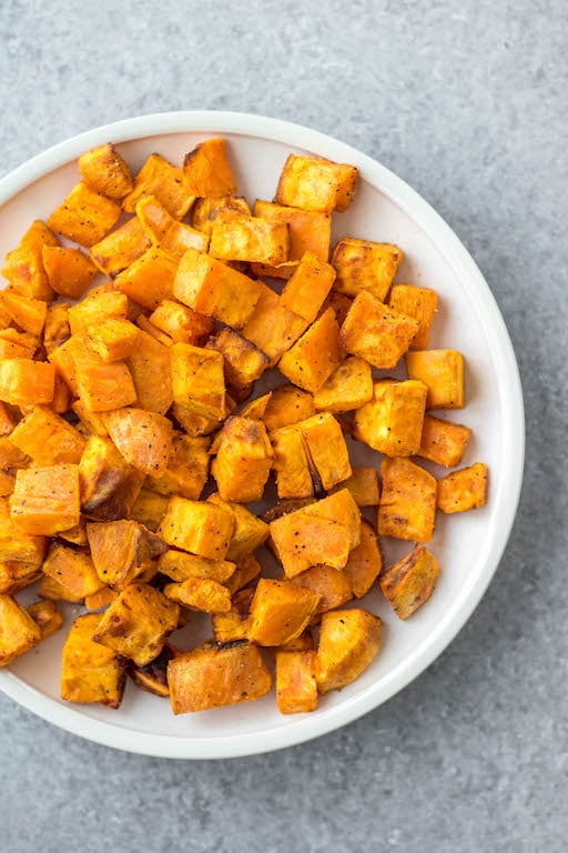 These air fryer roasted sweet potatoes are a quick and easy vegetable side for breakfast, dinner or meal prep. They're Whole30, paleo and gluten-free, and only take 15 minutes! With only 3 ingredients, these air fryer diced sweet potatoes cook in half the time as they would in the oven, and are perfectly crispy every time! #whole30vegetables #airfryer #sweetpotatorecipes #airfryerpotatoes