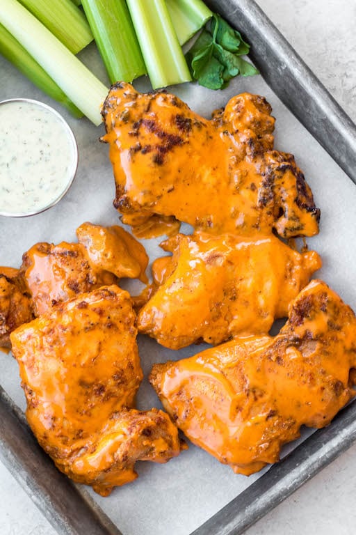 These buffalo chicken thighs are naturally gluten and dairy free. This versatile recipe can be made in both by being baked in the oven and cooked in the air fryer. It is made with a total of 5 staple ingredients you likely already have on hand alongside boneless chicken thighs and your go-to buffalo sauce. They take less than 30 minutes, and make an easy, healthy, dinner everyone will love.