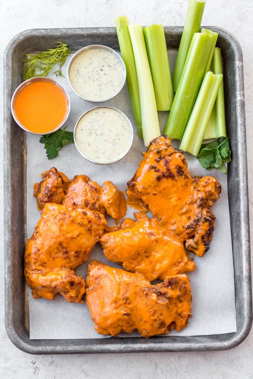 These buffalo chicken thighs are naturally gluten and dairy free. This versatile recipe can be made in both by being baked in the oven and cooked in the air fryer. It is made with a total of 5 staple ingredients you likely already have on hand alongside boneless chicken thighs and your go-to buffalo sauce. They take less than 30 minutes, and make an easy, healthy, dinner everyone will love. #healthychickenrecipes #glutenfreerecipes #buffalochicken #30minutemeals #whole30recipes #whole30chicken