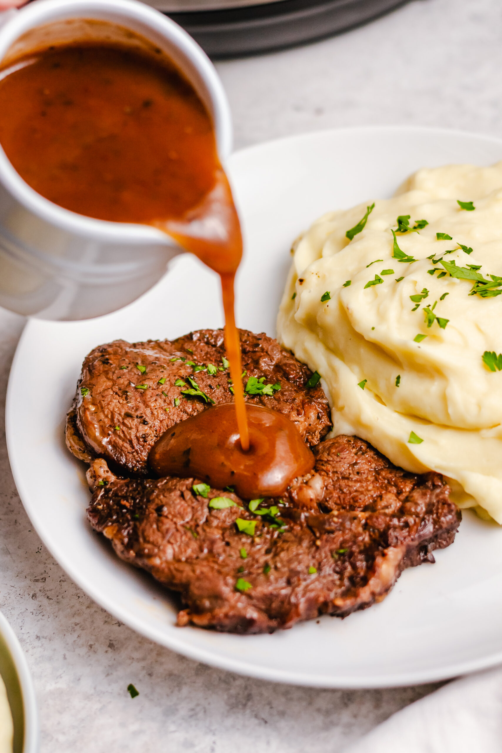 This instant pot steak is so flavorful and so easy. It cooks in the pressure cooker in under 20 minutes, and is perfect for a quick weeknight recipe. A delicious gravy can be made right in the instant pot with the juices to serve over the steak or with mashed potatoes, and everything is gluten free, Whole30, low carb so everyone can enjoy this healthy dinner. #instantpotsteak #pressurecookersteak #instantpotbeef #whole30instantpot