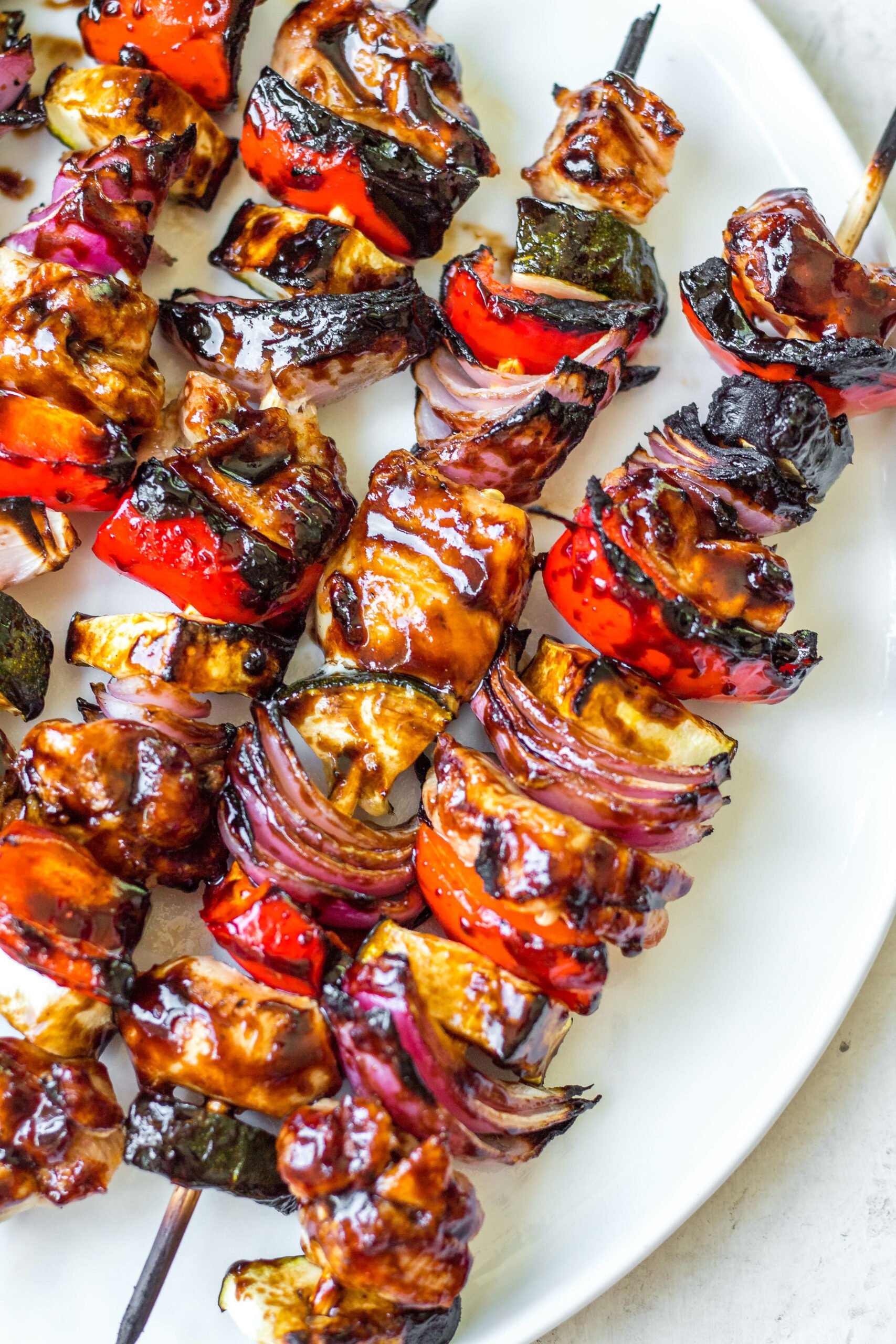 This honey balsamic grilled chicken kabob recipe is perfect for any summer dinner or family gathering. Made with lots of vegetables including zucchini, red onion and red pepper, these grilled chicken kabobs are quick to prep and grill, and glazed with an easy honey balsamic sauce! They're gluten free, low carb and paleo, so everyone can and will enjoy! #grilledchicken #chickenkabobs #balsamic #grilling