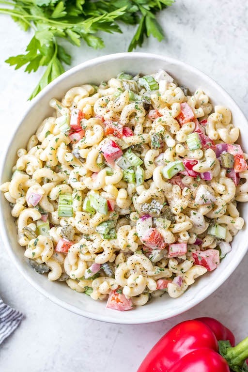 This easy, creamy macaroni salad is a flavorful pasta salad side dish that is the perfect combination of sweet and tart. The mayo based dressing is simple and not too overpowering, and it's sure to be a hit at every potluck or BBQ this summer! Made with sweet pickles, red onion, celery and red pepper, it can be made gluten free, dairy free, vegan and in under 30 minutes! #creamypastasalad #veganmacaronisalad #macaronisalad #sidedish