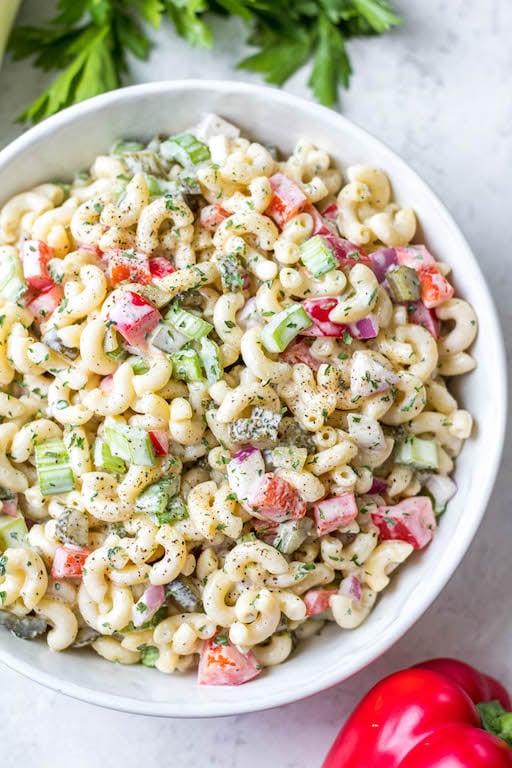 This easy, creamy macaroni salad is a flavorful pasta salad side dish that is the perfect combination of sweet and tart. The mayo based dressing is simple and not too overpowering, and it's sure to be a hit at every potluck or BBQ this summer! Made with sweet pickles, red onion, celery and red pepper, it can be made gluten free, dairy free, vegan and in under 30 minutes! #creamypastasalad #veganmacaronisalad #macaronisalad #sidedish