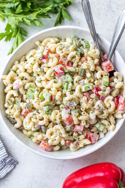 This easy, creamy macaroni salad is a flavorful pasta salad side dish that is the perfect combination of sweet and tart. The mayo based dressing is simple and not too overpowering, and it's sure to be a hit at every potluck or BBQ this summer! Made with sweet pickles, red onion, celery and red pepper, it can be made gluten free, dairy free, vegan and in under 30 minutes! #creamypastasalad #veganmacaronisalad #macaronisalad #sidedish