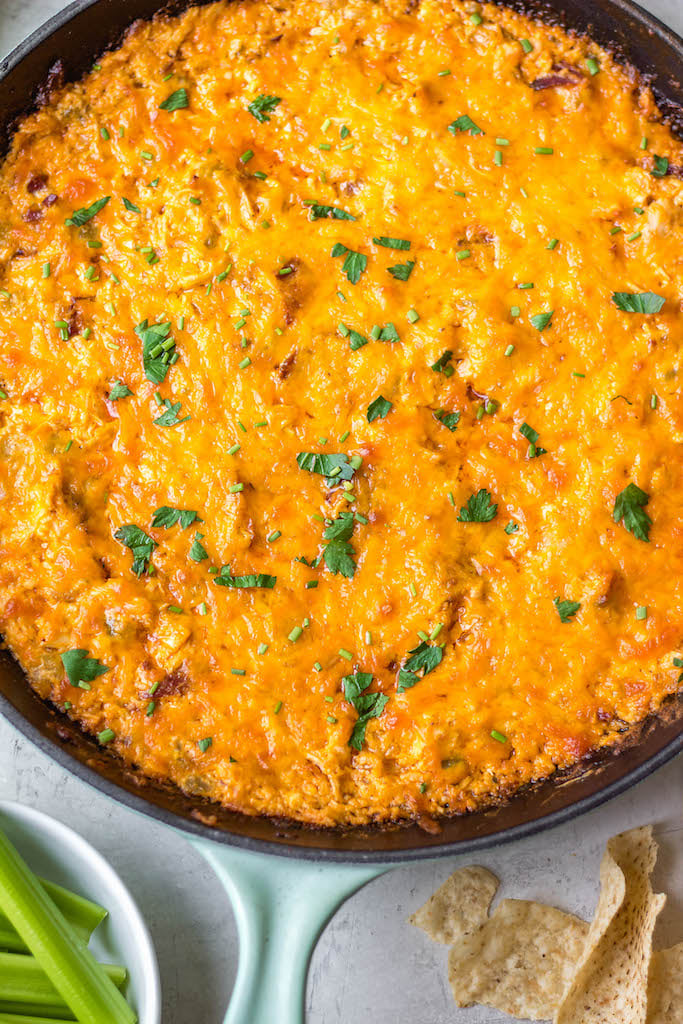 This smoked buffalo chicken dip recipe is so easy and always a crowd pleaser! With only 10 ingredients, it's a simple appetizer that can also be used in tacos, quesadillas, wraps and more. It doesn't take all day on the smoker making it perfect for a family summer gathering, and cooking it on a pellet grill infuses the perfect amount of smoke flavor! It's also low carb and gluten free! #buffalochickendip #smokerbuffalochickendip #buffalochickenrecipes