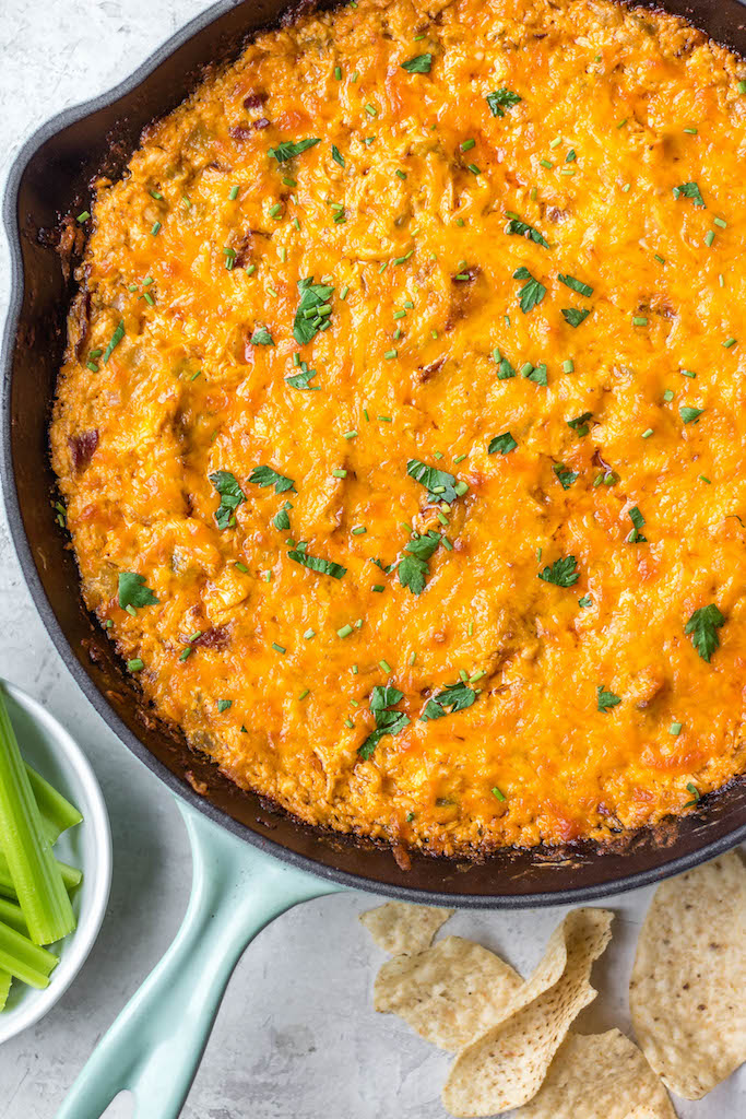 This smoked buffalo chicken dip recipe is so easy and always a crowd pleaser! With only 10 ingredients, it's a simple appetizer that can also be used in tacos, quesadillas, wraps and more. It doesn't take all day on the smoker making it perfect for a family summer gathering, and cooking it on a pellet grill infuses the perfect amount of smoke flavor! It's also low carb and gluten free! #buffalochickendip #smokerbuffalochickendip #buffalochickenrecipes