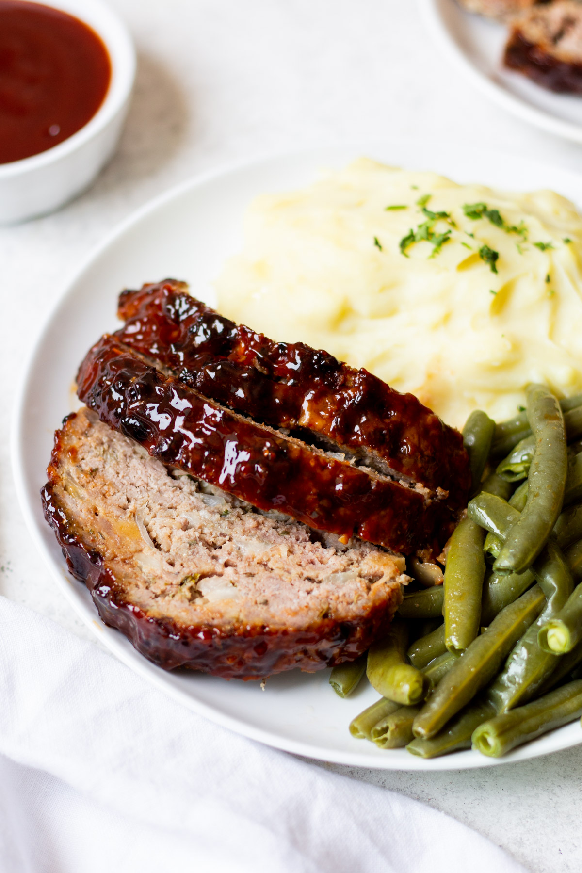 This air fryer meatloaf is a great, healthy recipe for getting a classic meal on the table for dinner. It uses very few ingredients and can be made gluten free easily. The air fryer caramelizes the sauce to perfection and makes for a juicy, flavorful meal. Use this meatloaf for an easy meal prep for the week ahead or divide the recipe into two loaves to save some to freeze for later. #glutenfreerecipes #healthydinnerrecipes #beefrecipes #airfryerrecipes #meatloaf