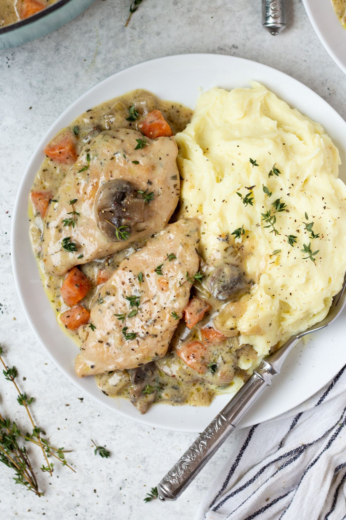 Making dutch oven chicken breast feels like an elevated dinner meal, but it's such an easy recipe to cook! It's a healthy dutch oven recipe that's also Whole30, low carb, gluten free and dairy free, and filled with vegetables like onions, celery and carrots, and the chicken breast is cooked in a creamy parsley and thyme sauce. It's a family friendly recipe that only uses one pot, and comes together in under an hour! #dutchoven #dutchovenchicken #chickenbreast #whole30dinner