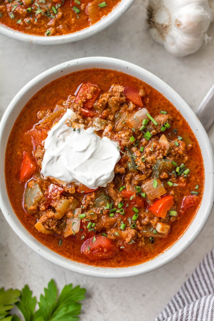 This beanless chili recipe is a quick and easy stovetop meal that cooks in just 30 minutes! It's Whole30, paleo, low carb and gluten-free, so it's a no bean chili that everyone can enjoy! Made with hearty vegetables like tomatoes, peppers, onions and mushrooms it's super filling without beans and makes delicious leftovers for meal prep or freezing. #beanlesschili #whole30chili #stovetopchili #ketochili #lowcarbchili