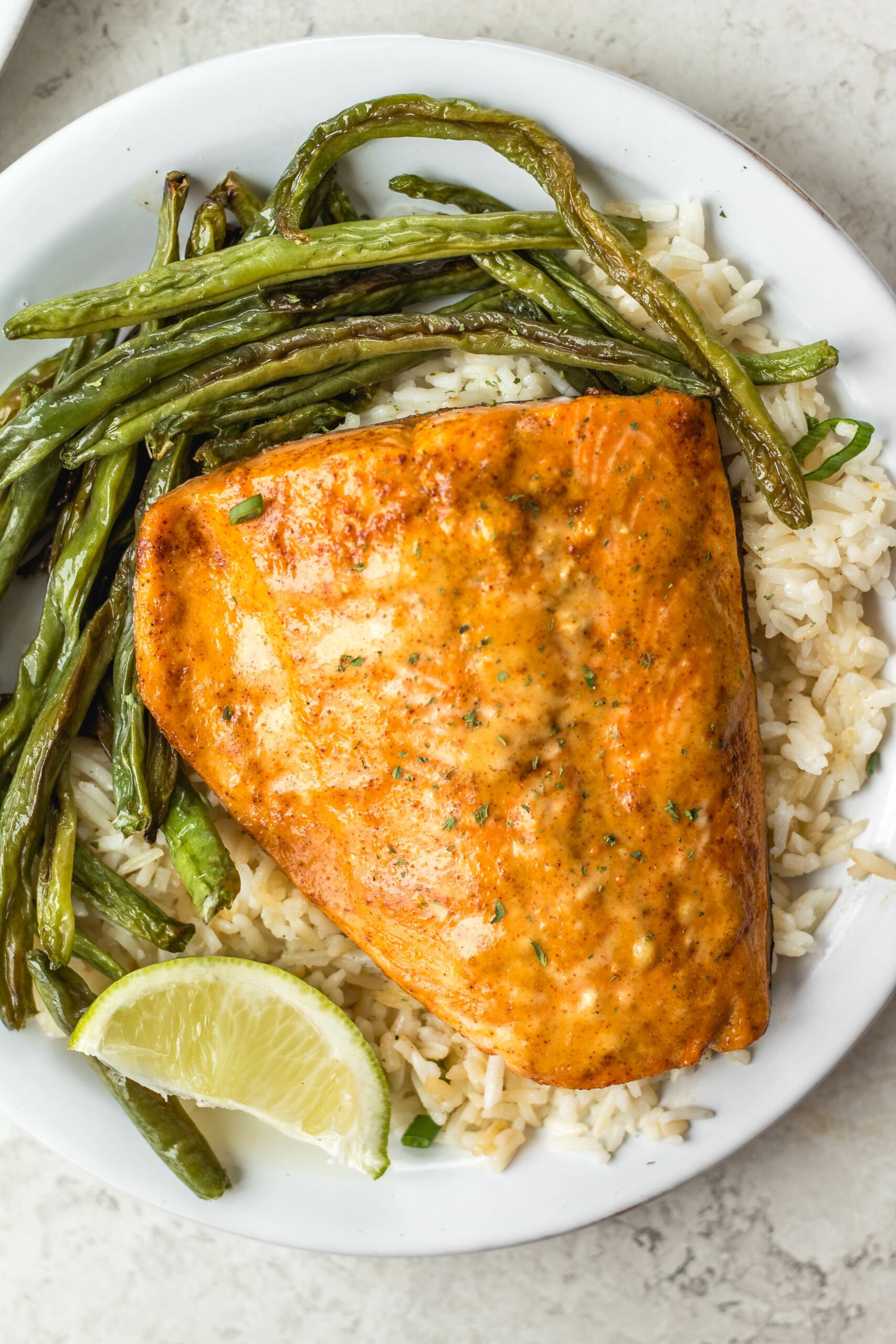 Bang Bang salmon with homemade Bang Bang sauce is both dairy free and gluten free. It takes about 10 minutes to cook and uses only a few easy ingredients. Made in the oven on a sheet pan, it's a breeze for cleanup and makes for an easy win for meal prep or dinner anytime. #homemadebangbangsauce #glutenfreesalmon #diaryfreesalmon #salmonrecipes #10minutemeals #bangbangsalmon