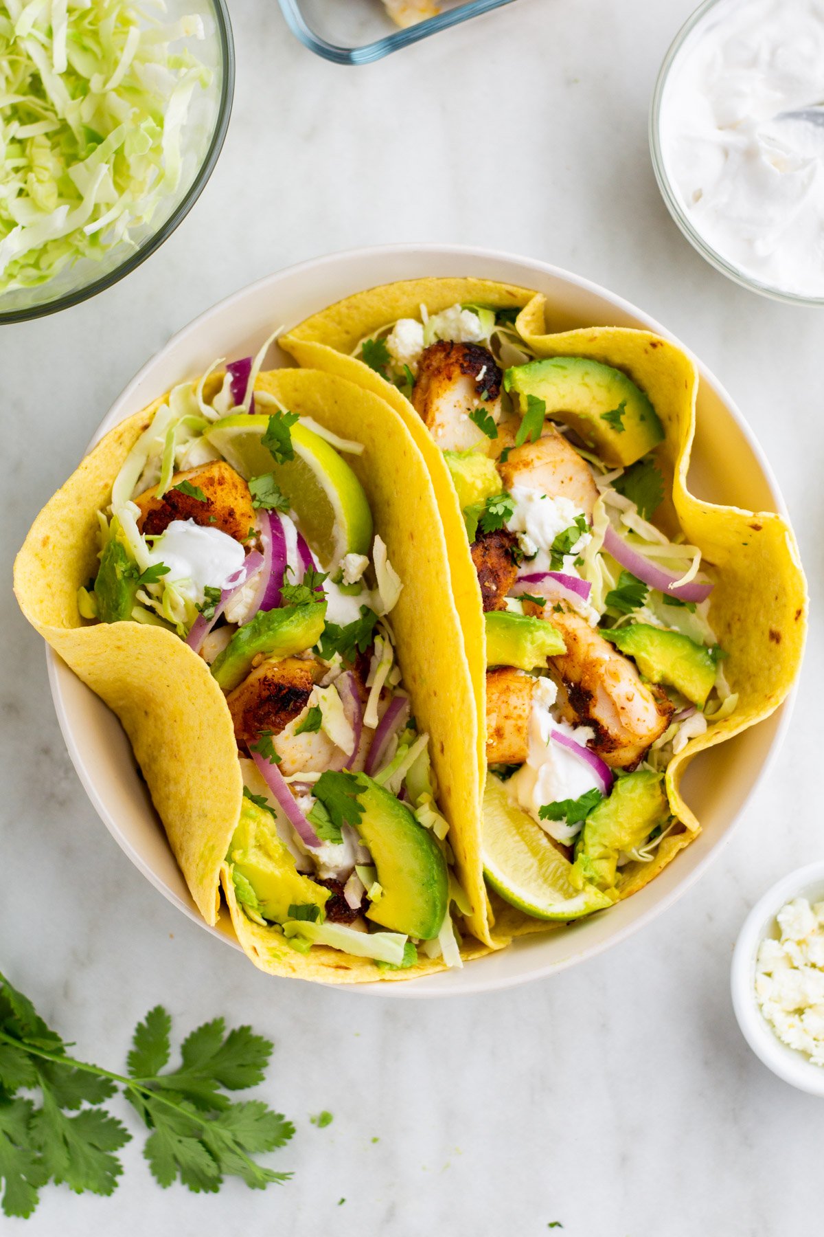 Halibut fish tacos are perfect for an easy weeknight meal. This recipe takes only ten minutes to make and is both dairy and gluten free, along with paleo, Whole30 and low carb. The homemade dairy free sour cream in this recipe is incredibly simple to make and works perfectly with the halibut fillets. Fish tacos are perfect to make for family meals, large and small, or to meal prep for the week ahead. #fishtacos #halibut #easyhalibutrecipes #10minutemeals #glutenfreerecipes #dairyfreerecipes #glutenfreedairyfreerecipes #easydinnerrecipes