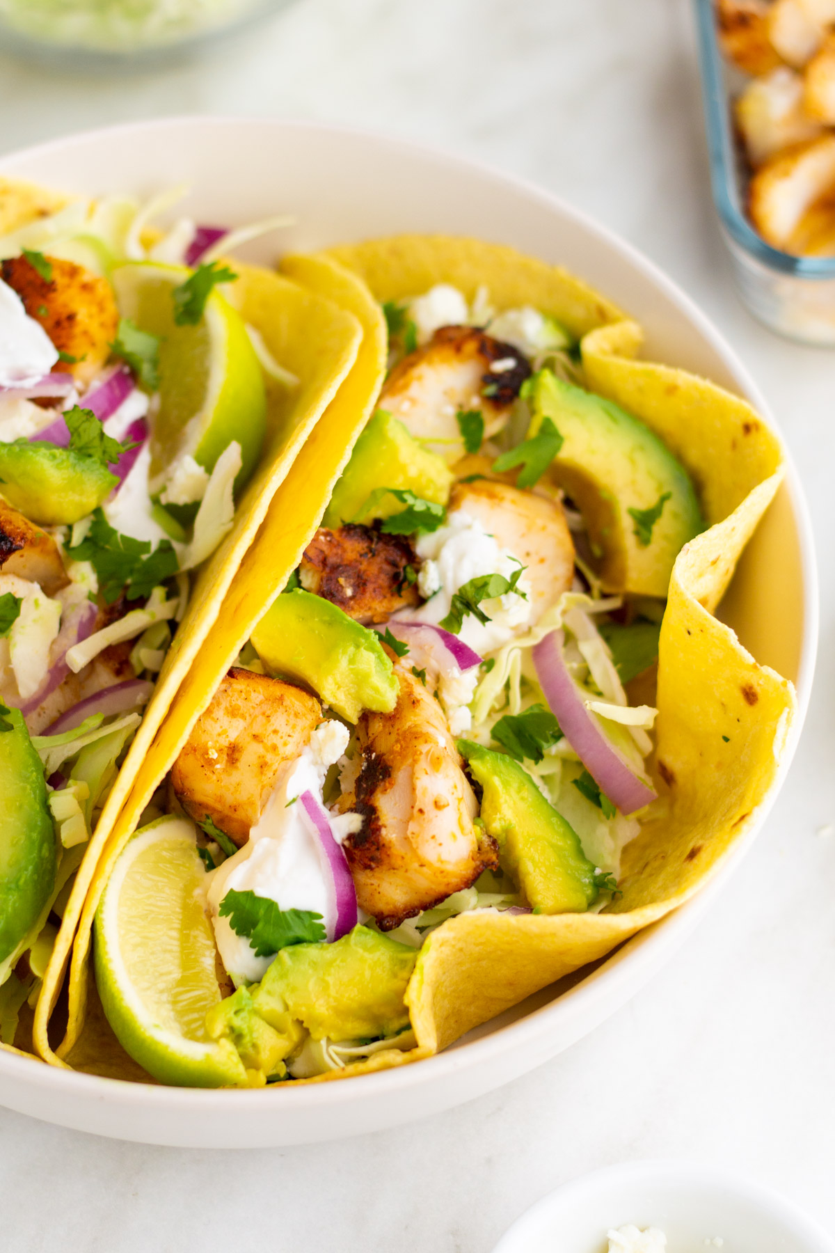 Halibut fish tacos are perfect for an easy weeknight meal. This recipe takes only ten minutes to make and is both dairy and gluten free, along with paleo, Whole30 and low carb. The homemade dairy free sour cream in this recipe is incredibly simple to make and works perfectly with the halibut fillets. Fish tacos are perfect to make for family meals, large and small, or to meal prep for the week ahead. #fishtacos #halibut #easyhalibutrecipes #10minutemeals #glutenfreerecipes #dairyfreerecipes #glutenfreedairyfreerecipes #easydinnerrecipes