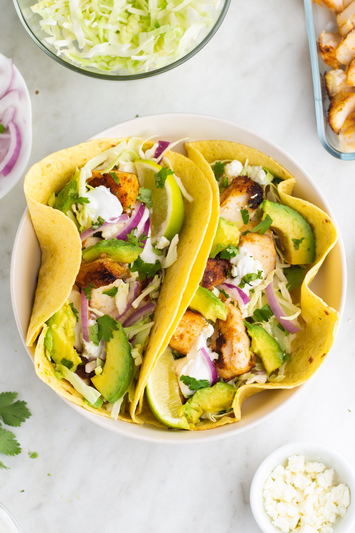 Halibut fish tacos are perfect for an easy weeknight meal. This recipe takes only ten minutes to make and is both dairy and gluten free, along with paleo, Whole30 and low carb. The homemade dairy free sour cream in this recipe is incredibly simple to make and works perfectly with the halibut fillets. Fish tacos are perfect to make for family meals, large and small, or to meal prep for the week ahead. #fishtacos #halibut #easyhalibutrecipes #10minutemeals #glutenfreerecipes #dairyfreerecipes #glutenfreedairyfreerecipes #easydinnerrecipes